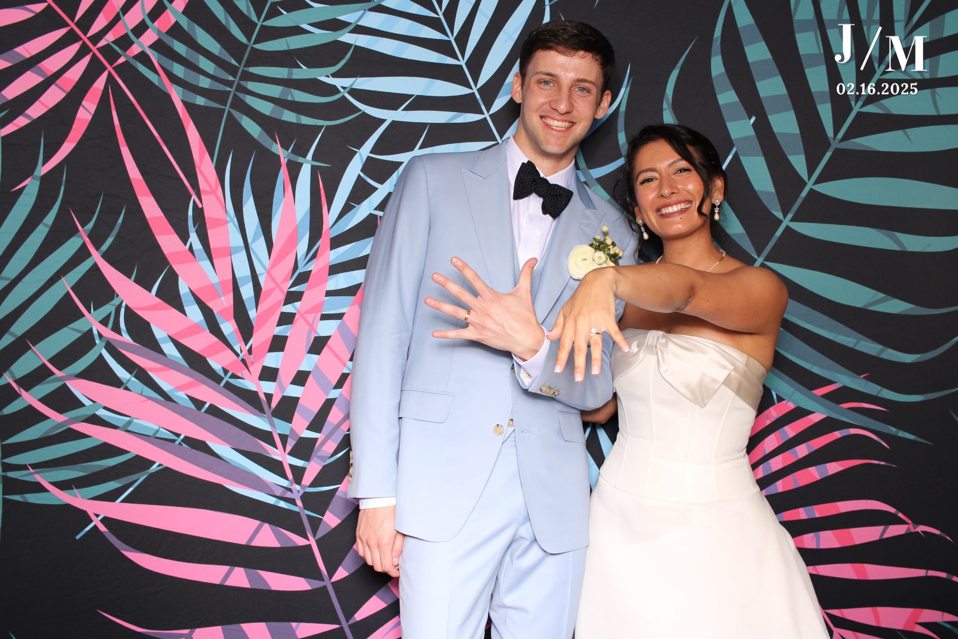 Bride and groom showing rings on tropical backdrop